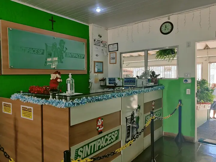 Balcão da recepção com o logo do SINTIPACESP e paredes verdes